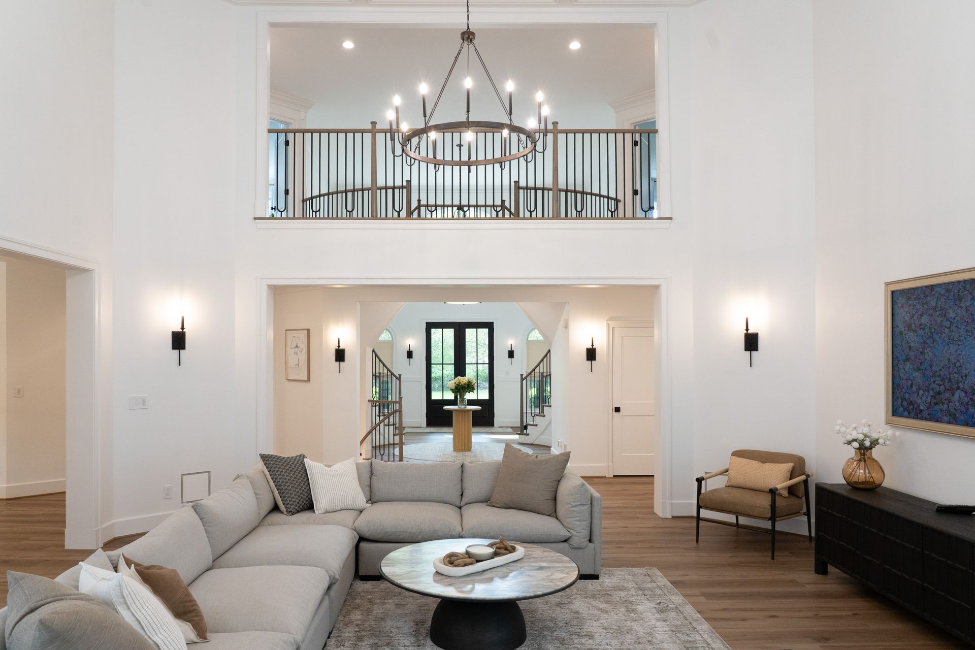 A living room with a couch , chairs , and a chandelier.