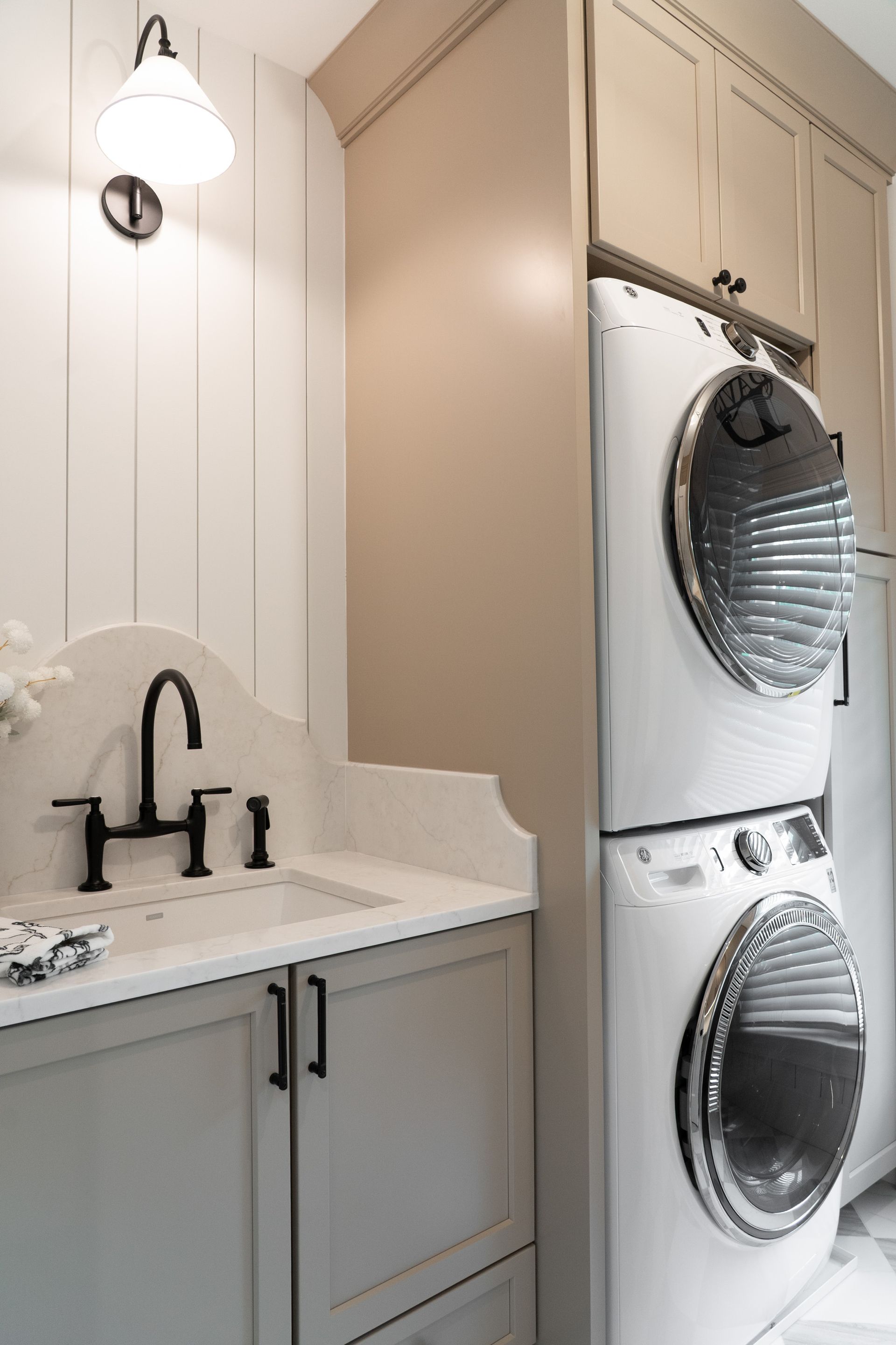 A laundry room with a washer and dryer stacked on top of each other.