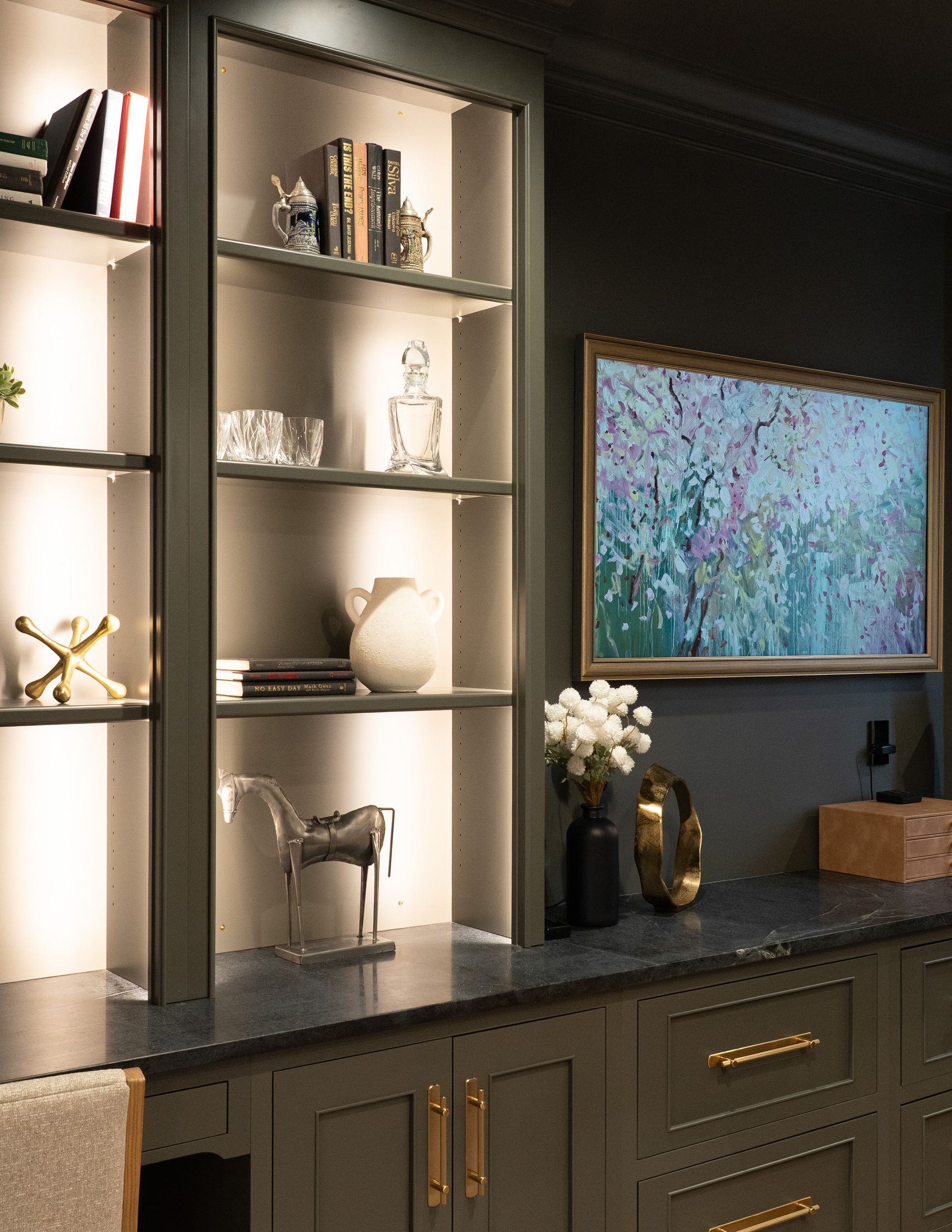 A living room with a painting on the wall and shelves