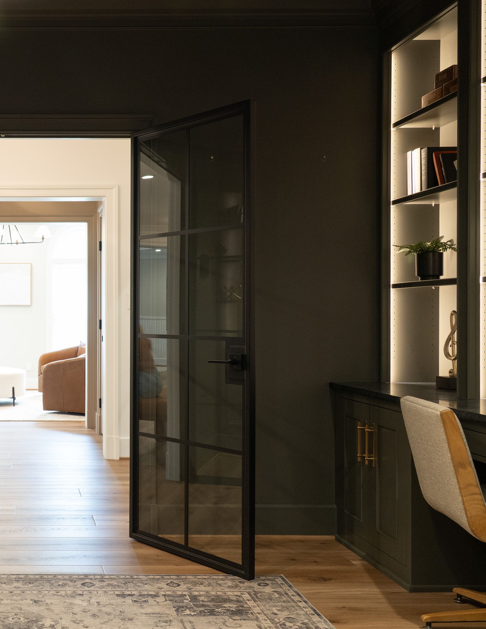 A room with a desk and chair and a glass door
