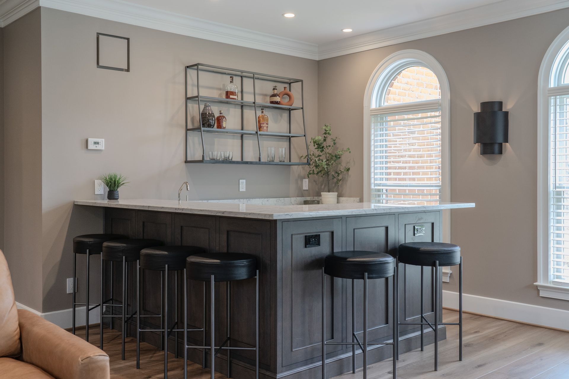 There is a large island in the middle of the room with stools.