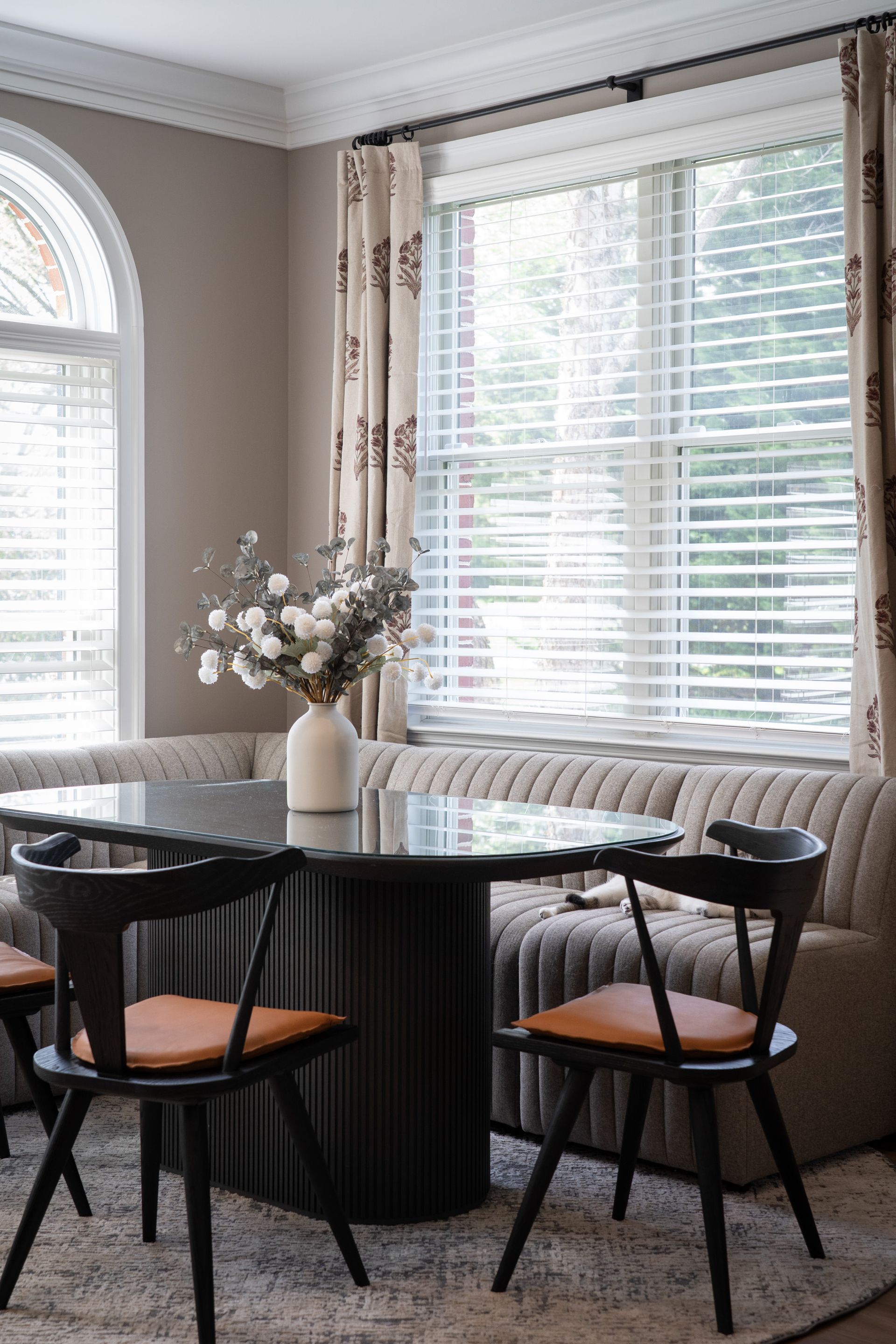 A living room with a table and chairs in front of a window.