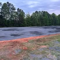 A large empty field with trees in the background.