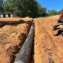 A large pipe is being installed in the dirt.