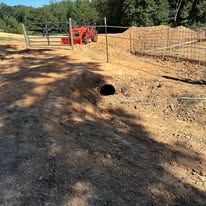 A dirt road with a hole in the middle of it.