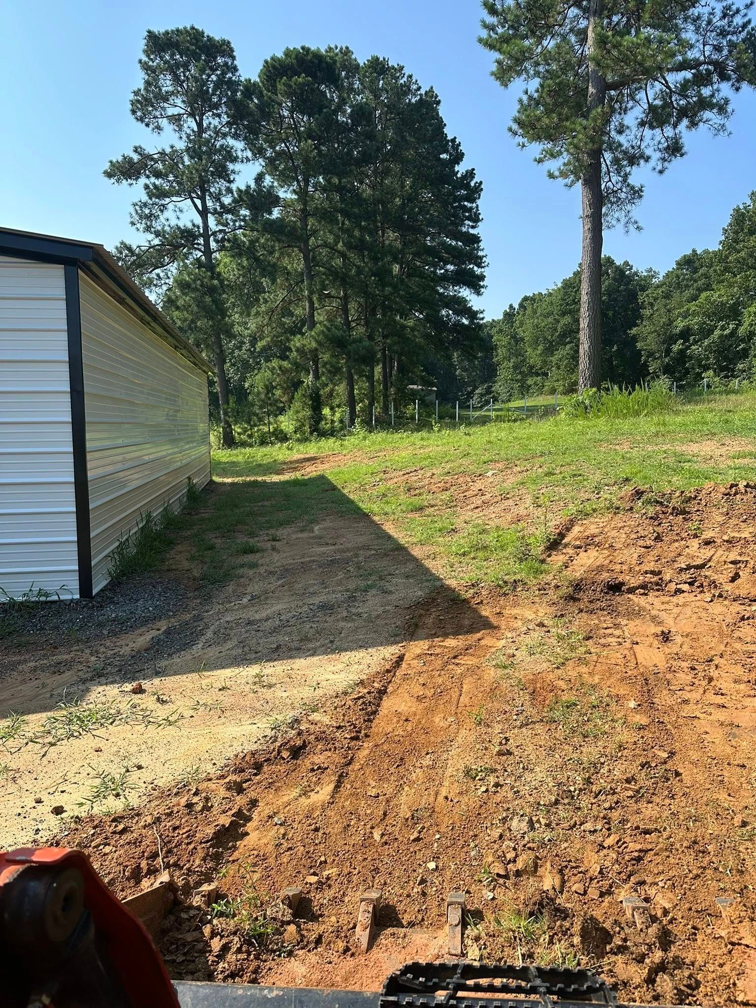 A person is driving a tractor down a dirt road.
