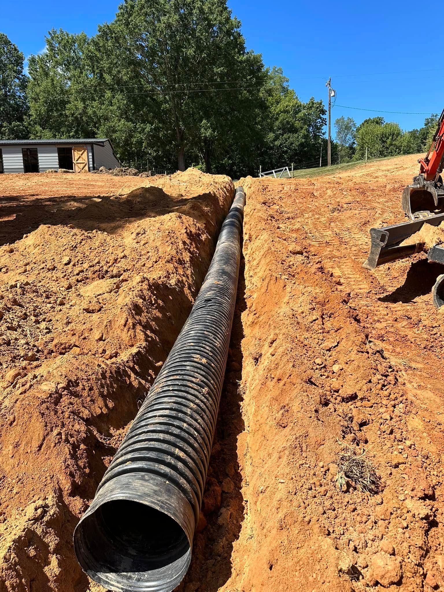 A large pipe is being installed in the dirt.