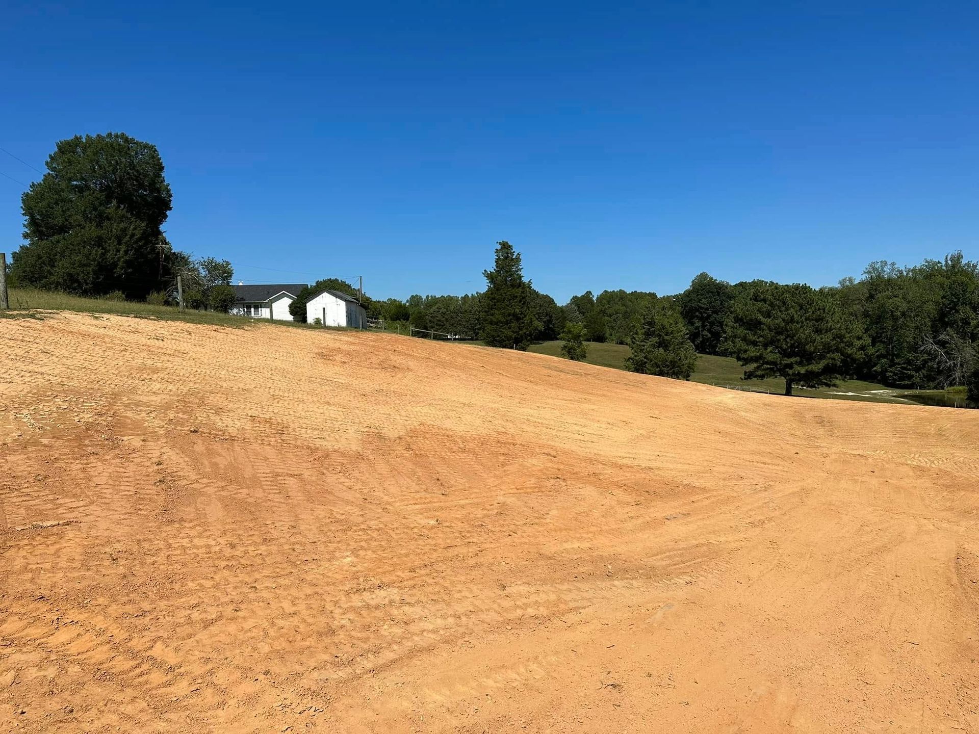 A dirt road with a house in the background