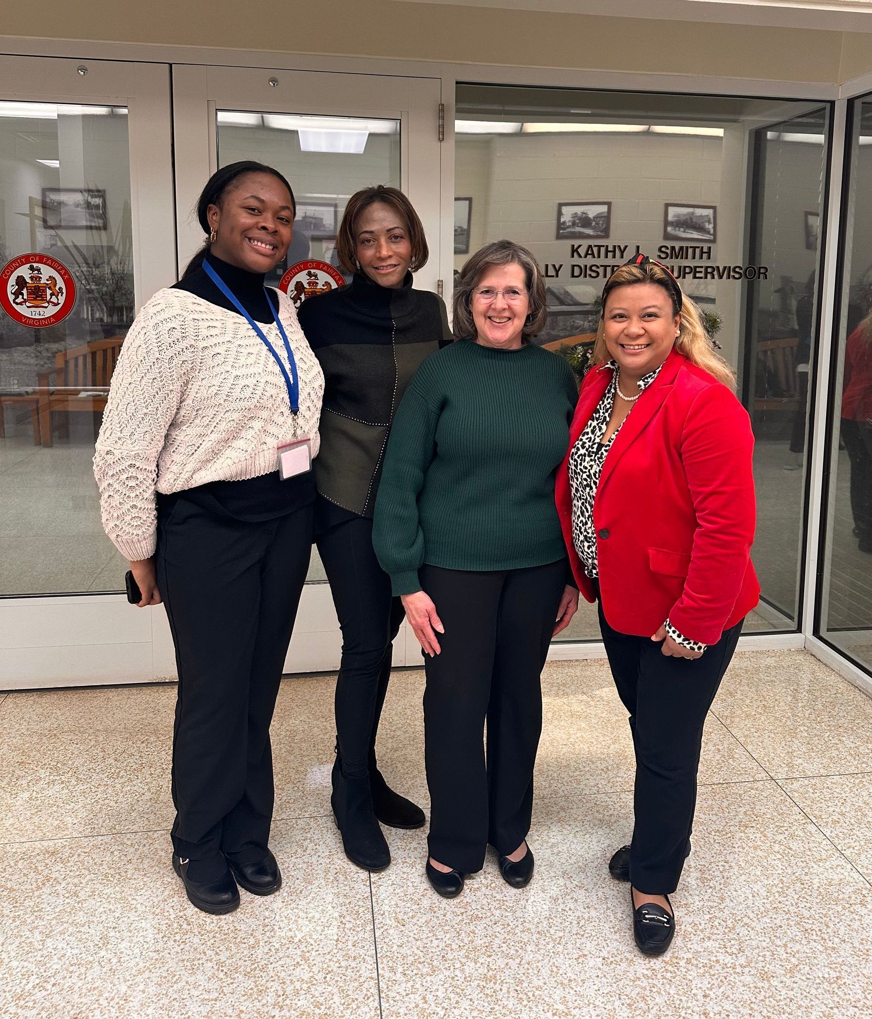 A group of women are posing for a picture in front of a building.
