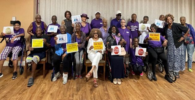 A group of people are posing for a picture while holding signs.