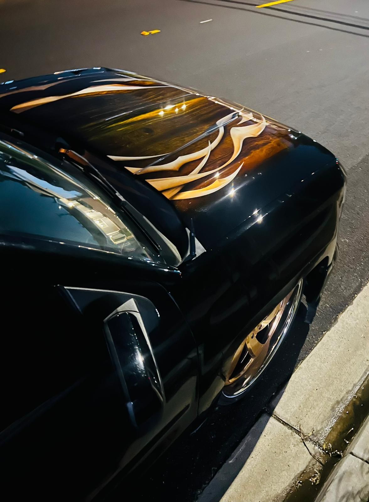 The hood of a car has a painting of a man riding a horse
