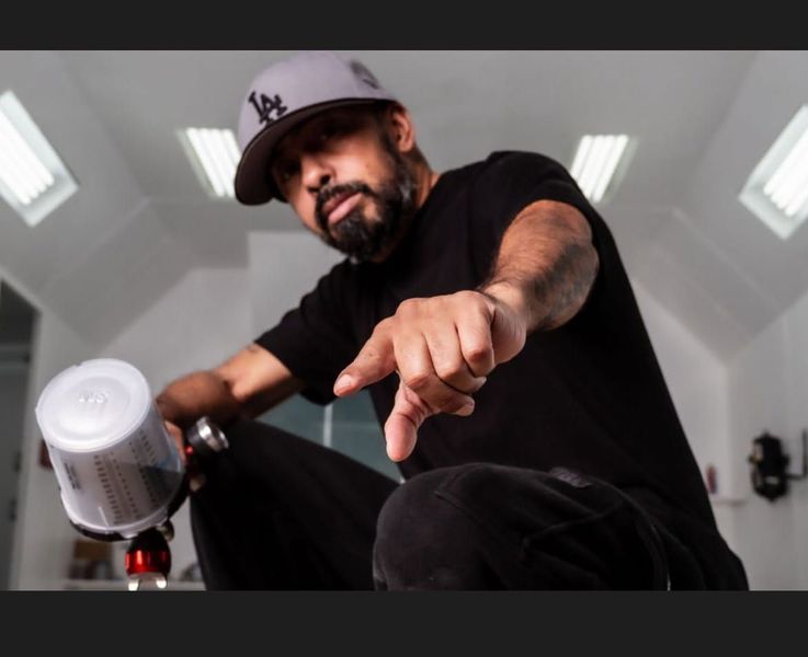 A man wearing a ny hat is pointing at something
