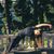 A woman in a black shirt is doing a yoga pose on a balcony.
