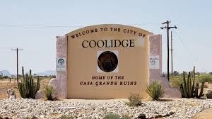 A welcome to the city of coolidge sign in the desert.