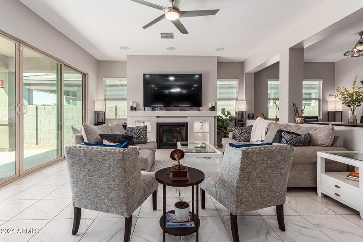 A living room with a couch , chairs , table and television.