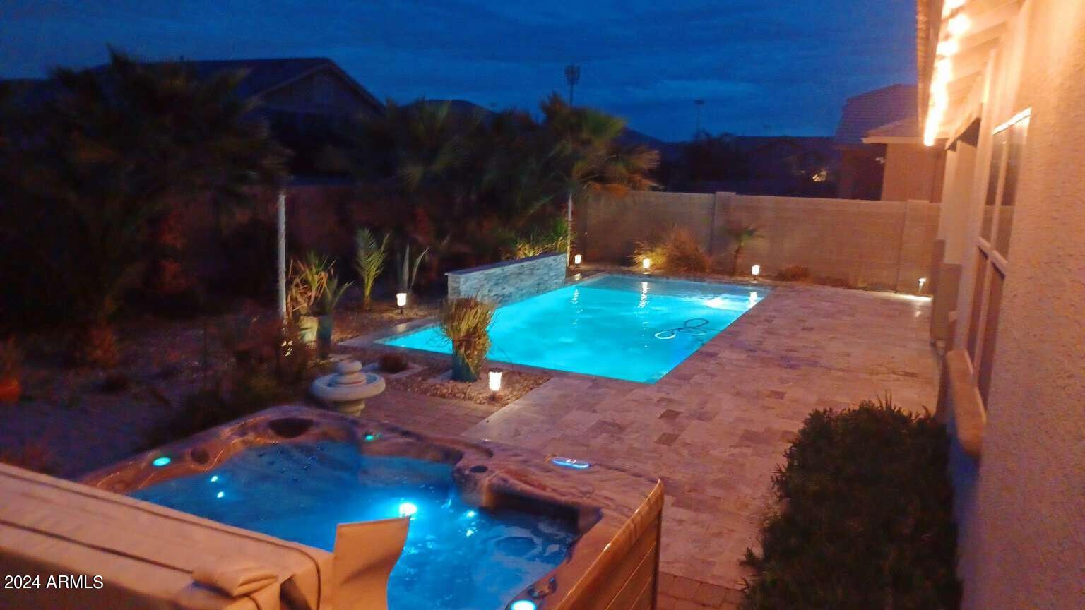 A large swimming pool is lit up at night