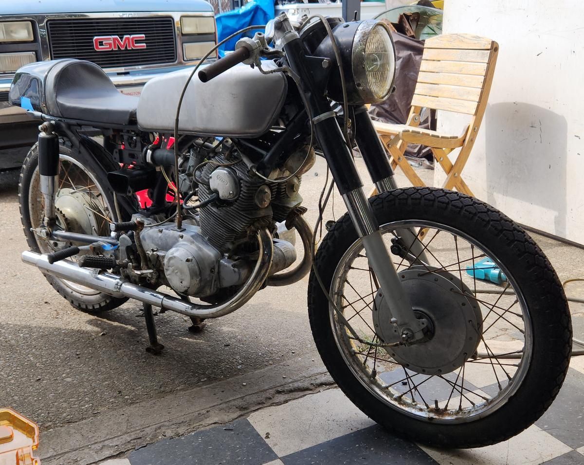 A motorcycle is parked in front of a gmc truck