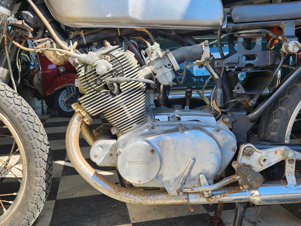 A motorcycle with the engine removed is sitting on a checkered floor.