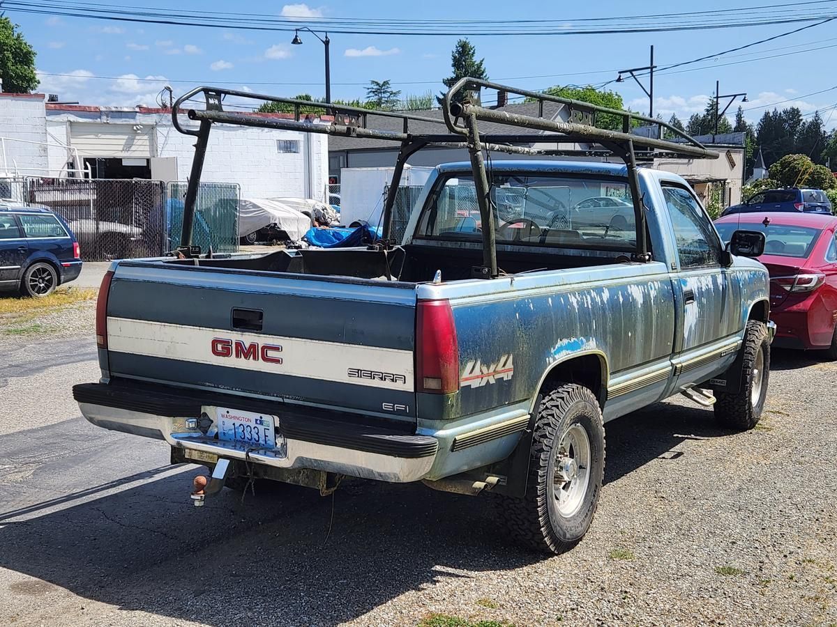 A gmc truck is parked on the side of the road