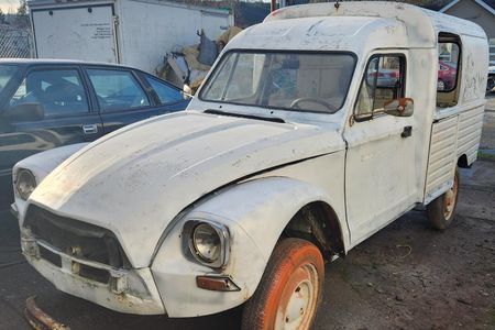 a white truck is parked next to a black car in a parking lot .