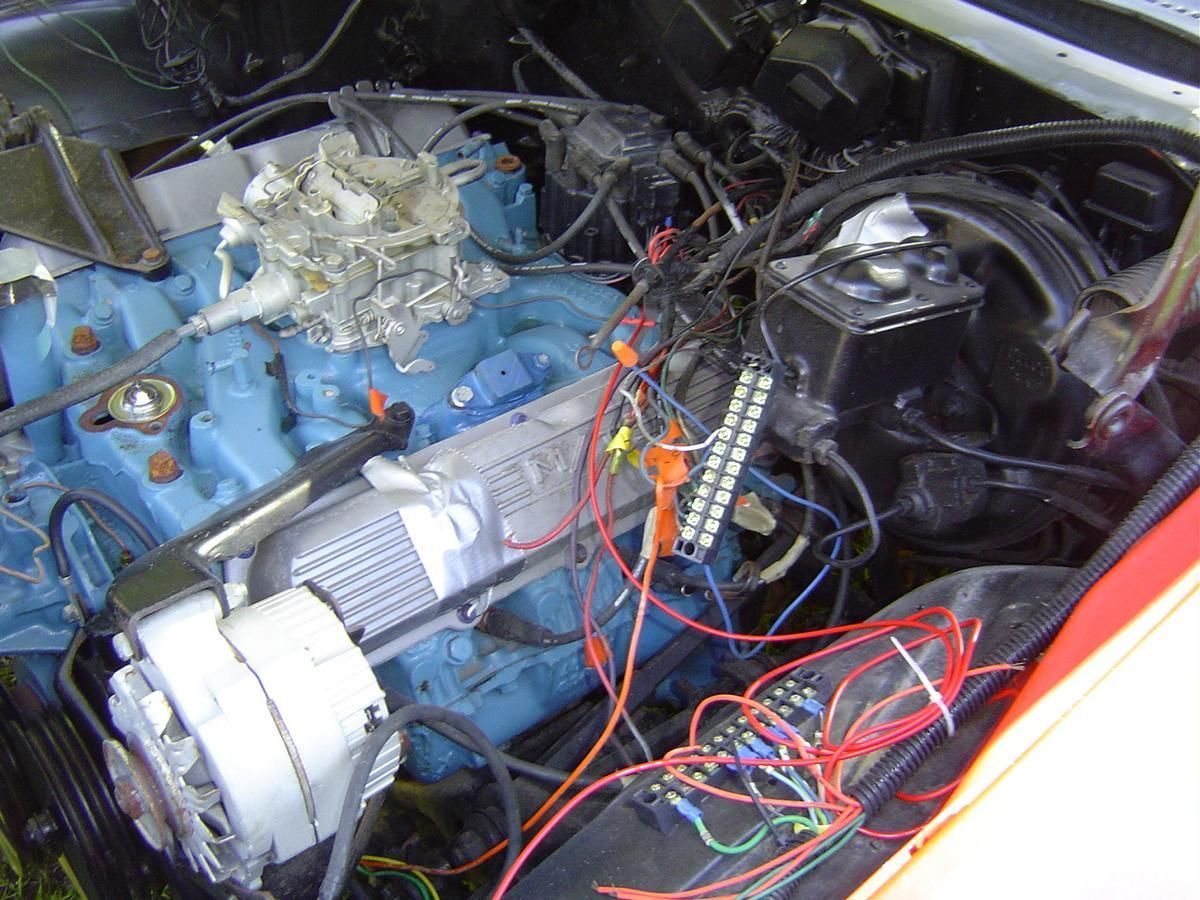 A car engine with a lot of wires coming out of it