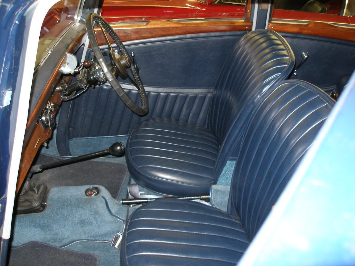 The inside of a car with blue seats and a steering wheel