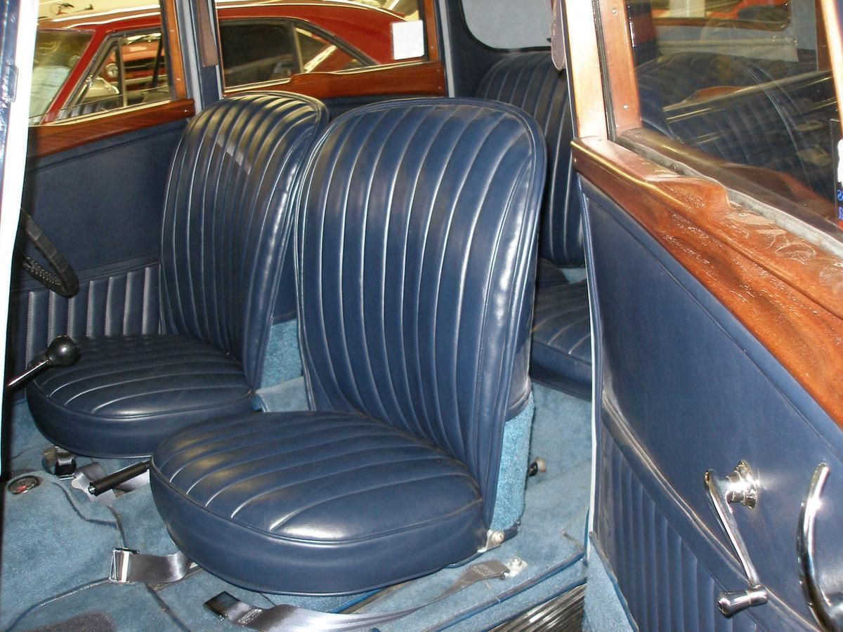 The inside of an old car with blue leather seats