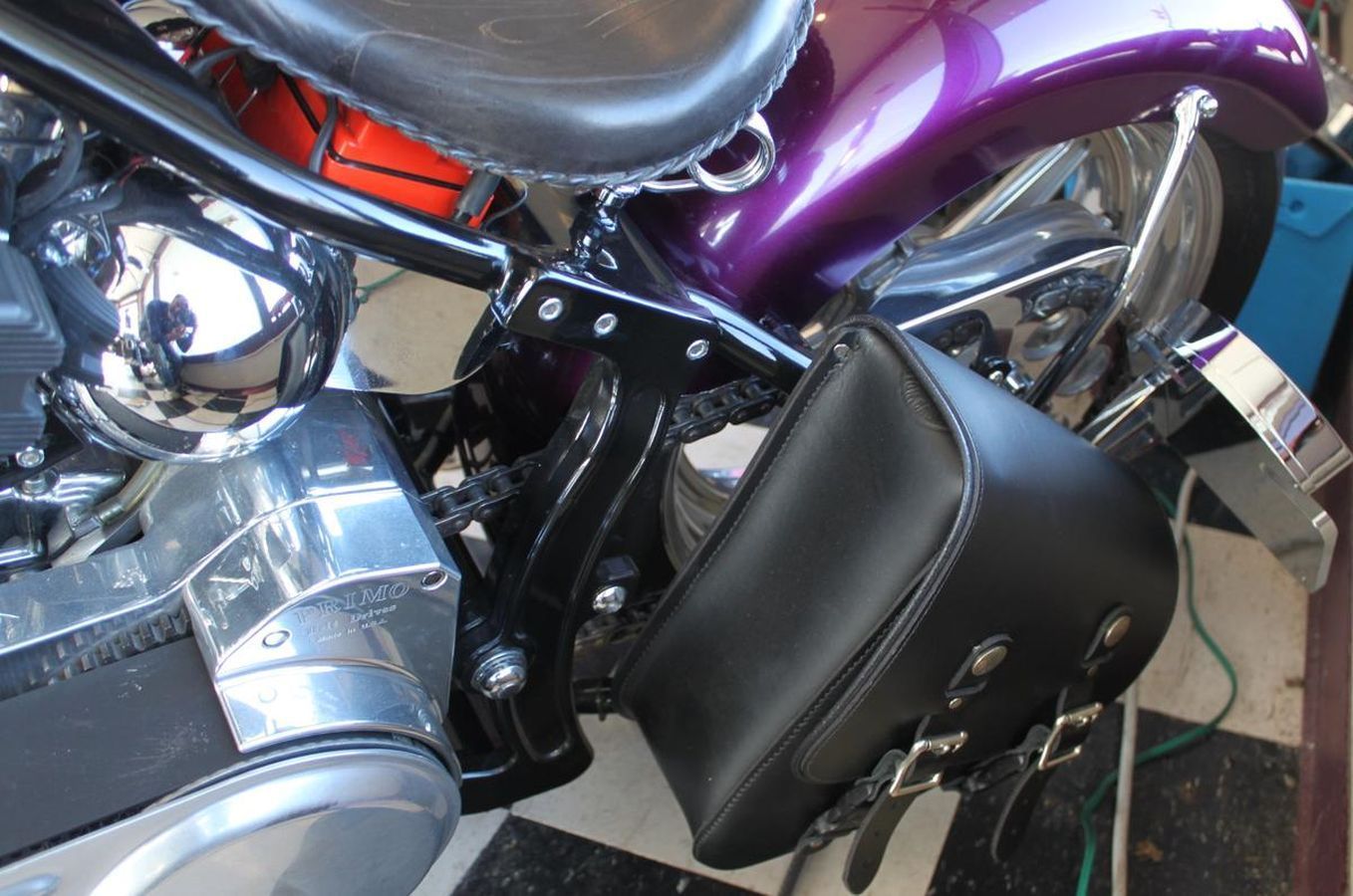 A black leather bag is attached to the side of a motorcycle