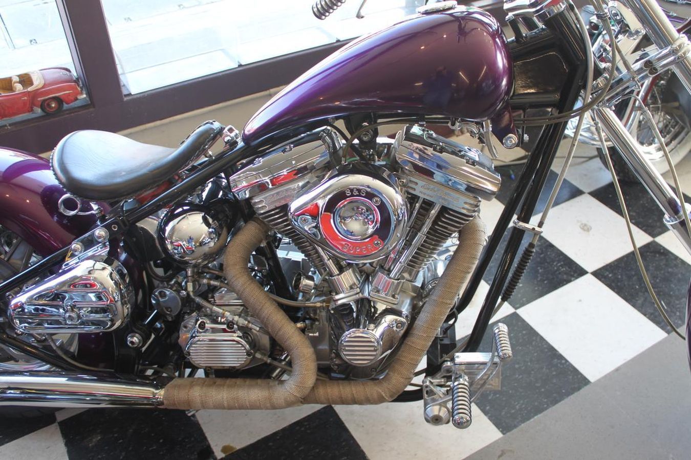 A purple motorcycle is parked on a checkered floor