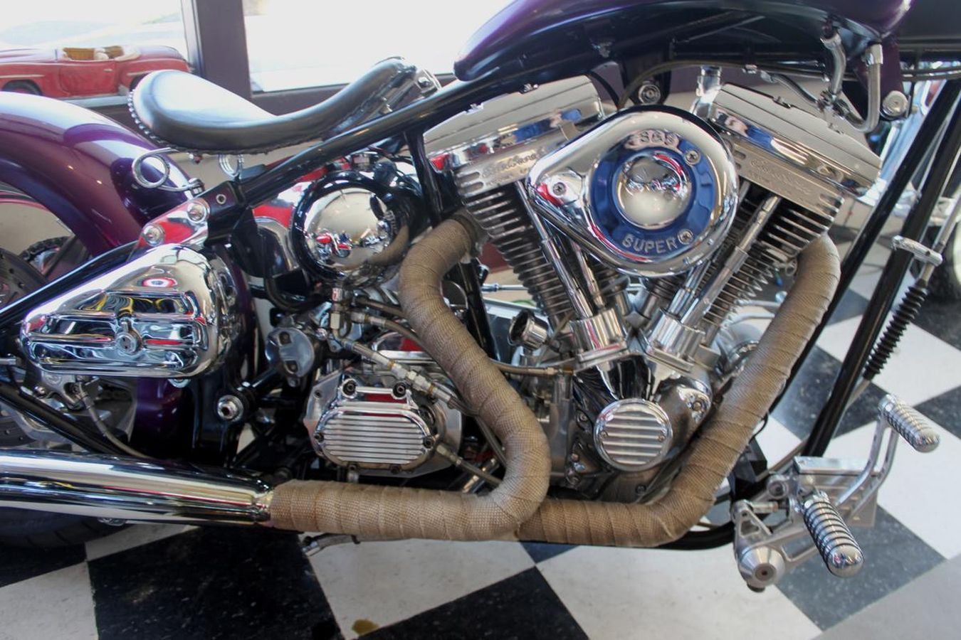 A close up of a motorcycle engine on a checkered floor