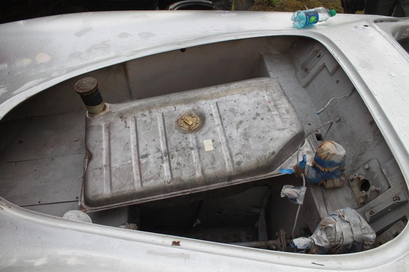 A fuel tank is sitting in the trunk of a car.