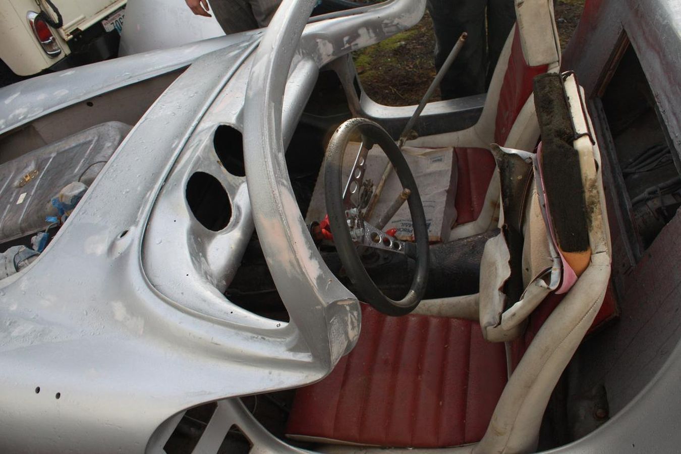 A silver car with a red seat and steering wheel