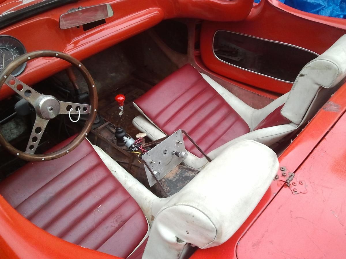 A red car with white seats and a steering wheel