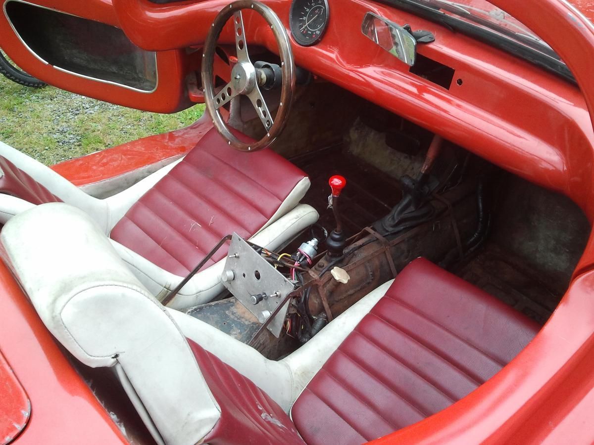 A red car with white seats and a steering wheel