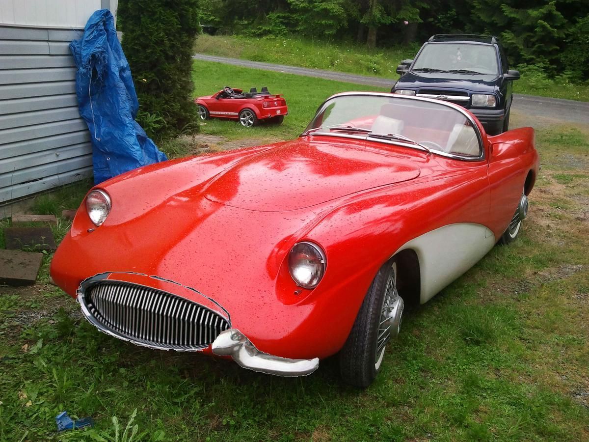 A red and white car is parked in the grass