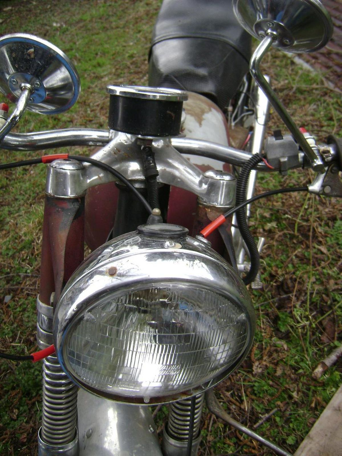 A close up of a motorcycle 's headlight and mirrors