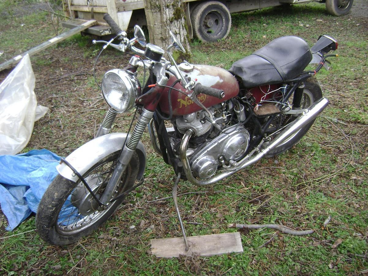 A red and silver motorcycle is parked in the grass