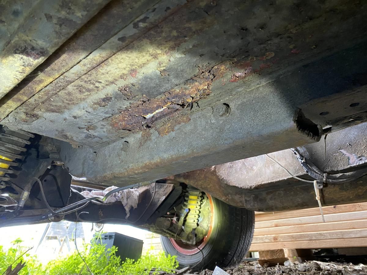 A close up of the underside of a car with a tire.