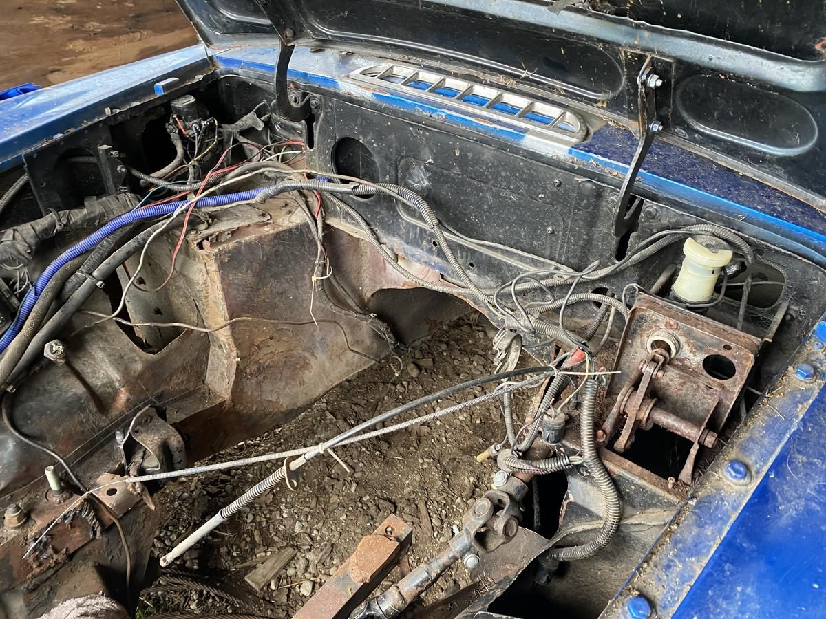 A blue car with the hood open and a lot of wires coming out of it.