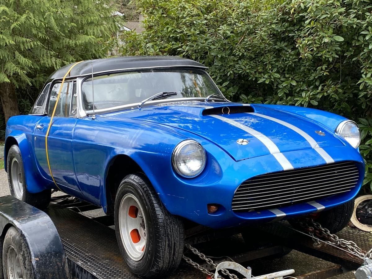 A blue sports car is sitting on top of a trailer.