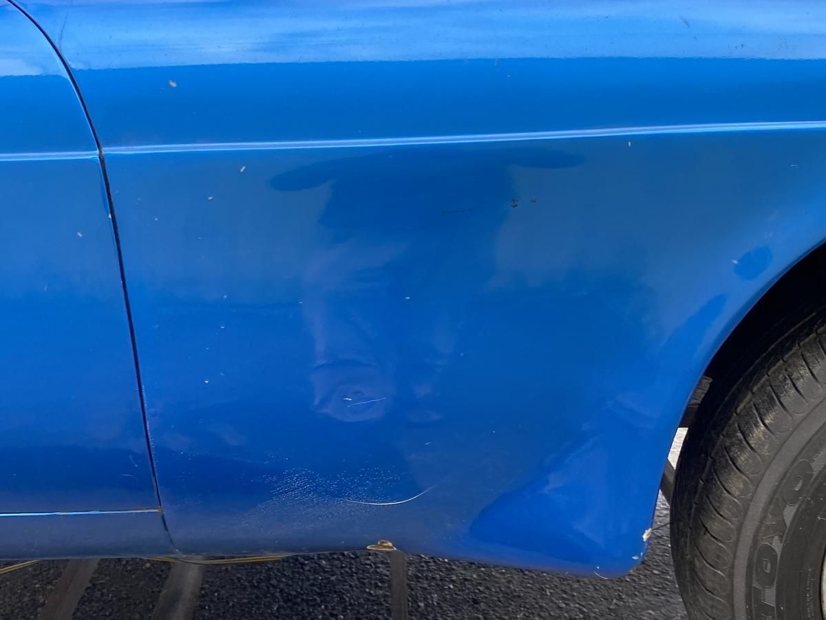 A close up of the side of a blue car.