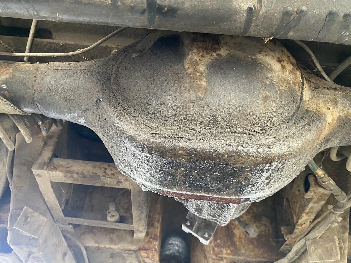 A close up of a rusty rear differential on a car.