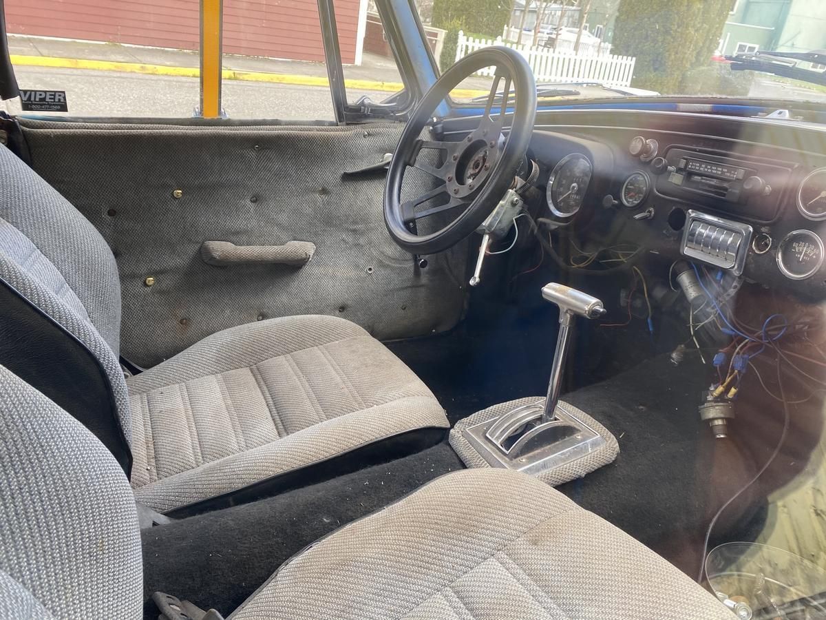 The inside of a car with a steering wheel and a shifter.