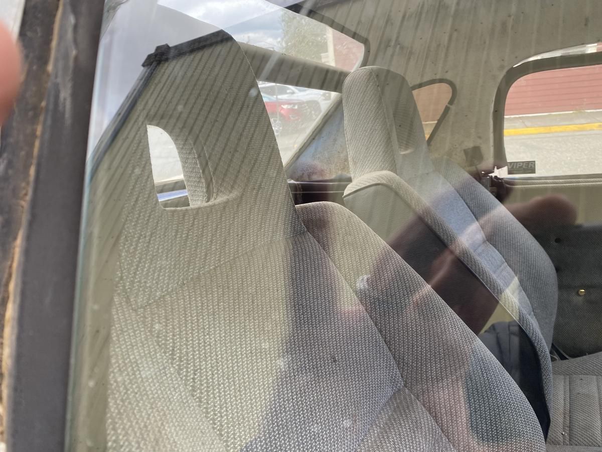 The inside of a car with a reflection of a person in the window.