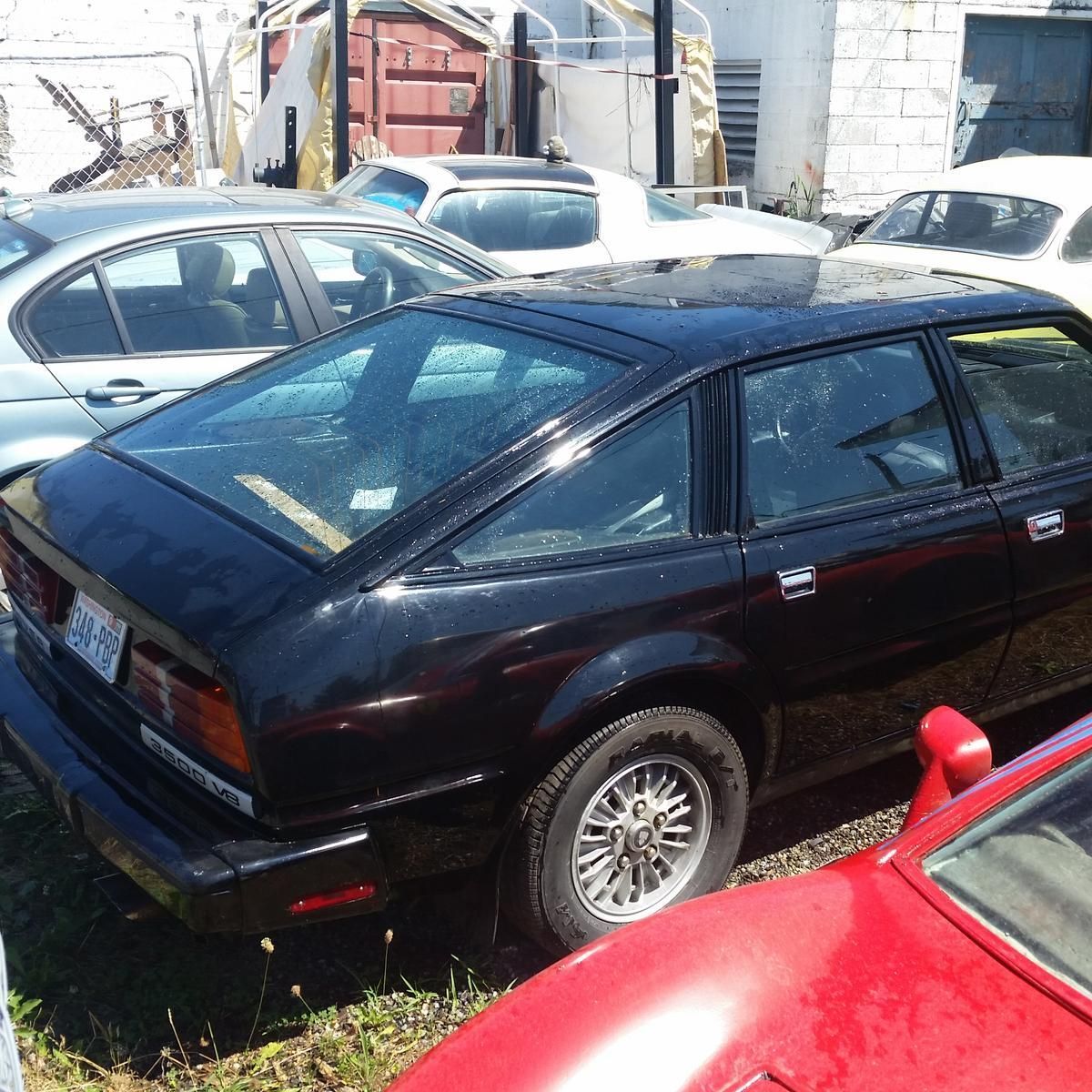 A black car is parked next to a red car