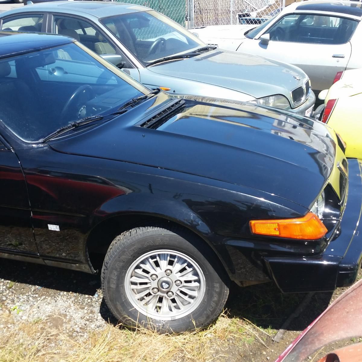 A black car is parked next to a yellow car