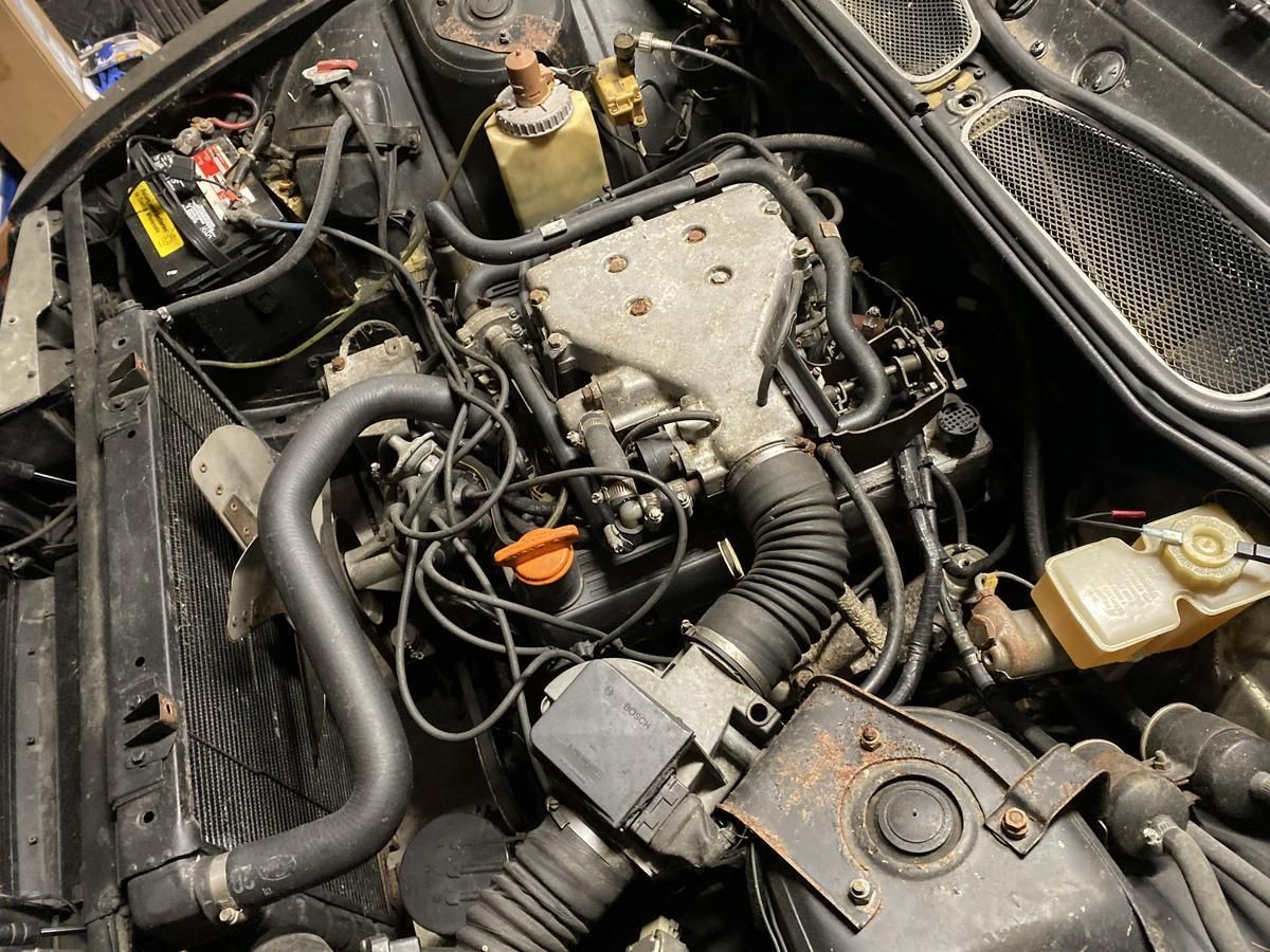 A close up of a car engine with the hood open