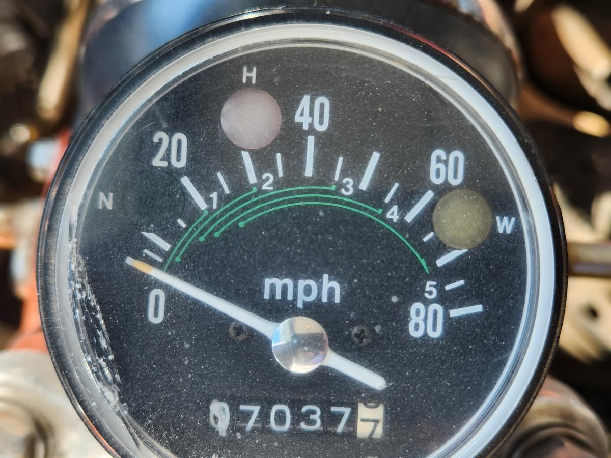 A close up of a speedometer with the number 7037 on it