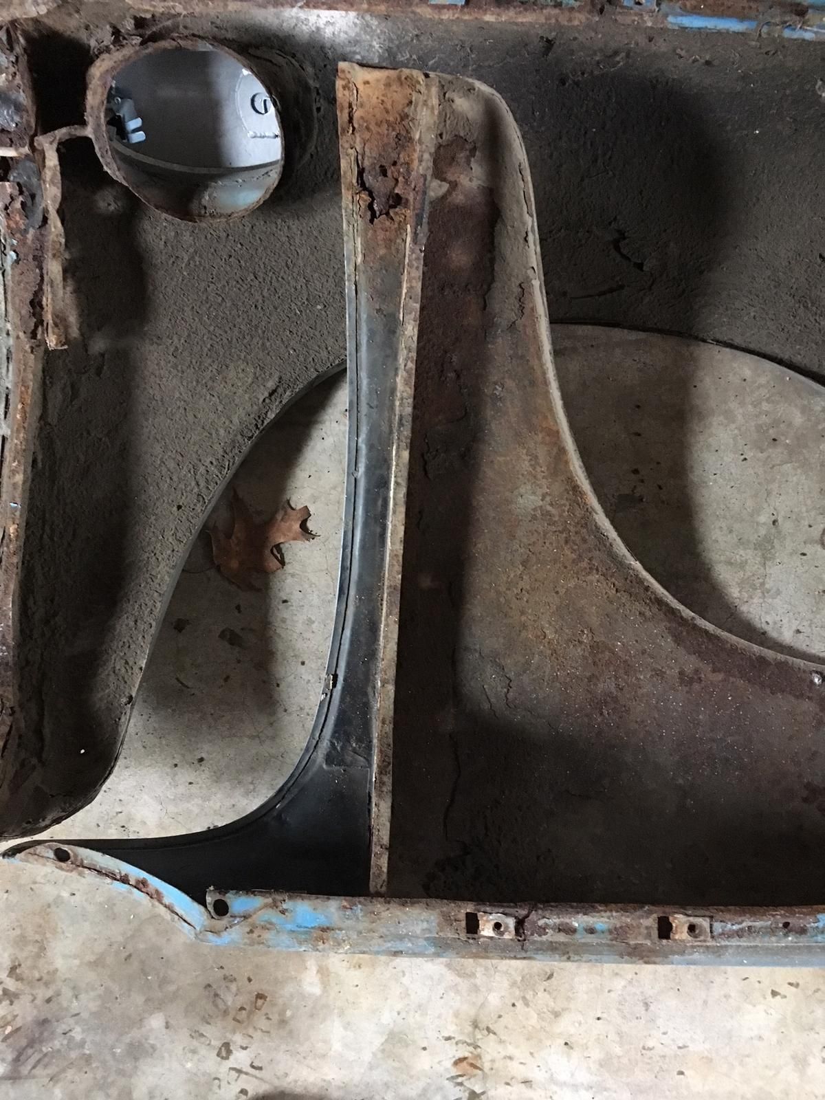 A close up of a rusty fender on a car.