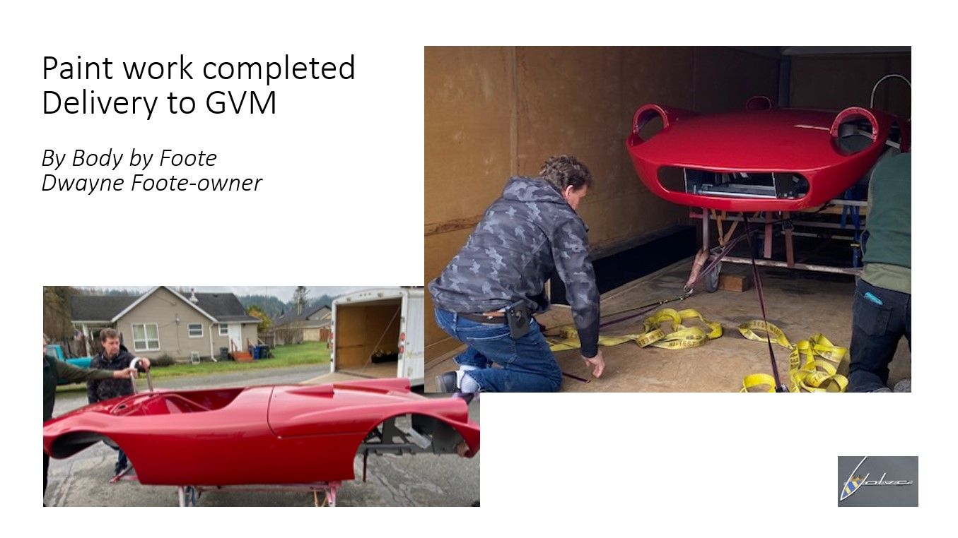 A man is painting a red car in a garage.